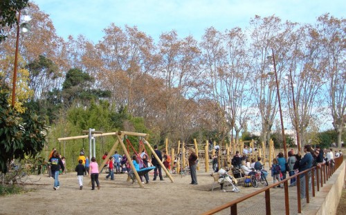 Un munt de gent a l'espai de jocs, nens i adults acompanyant-los